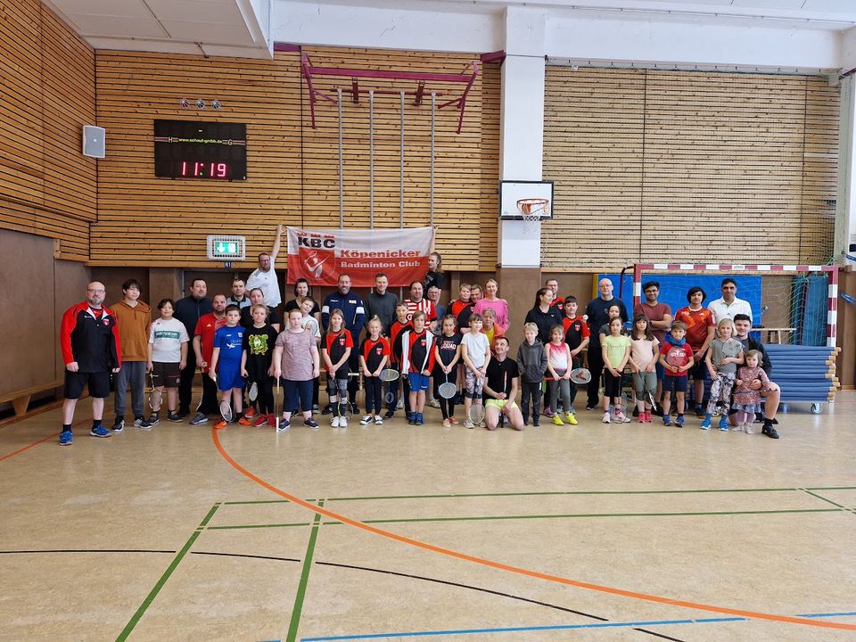 Gruppenfoto von Kindern, Jugendlichen und Betreuer:innen mit Schlägern vor dem KBC-Vereinsbanner